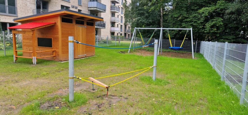 AWO Kita Kiwittsmoor Außenbereich mit Schaukeln und Geräteschuppen.