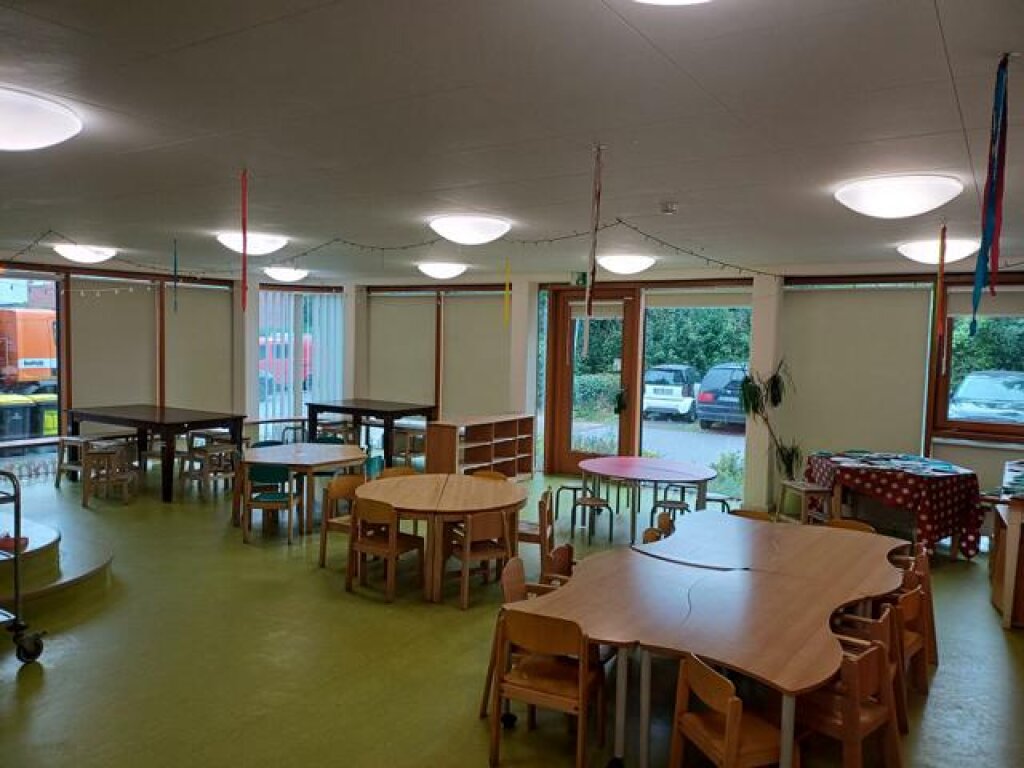 Gruppenraum mit Kindertischen der Kita Tigerente.