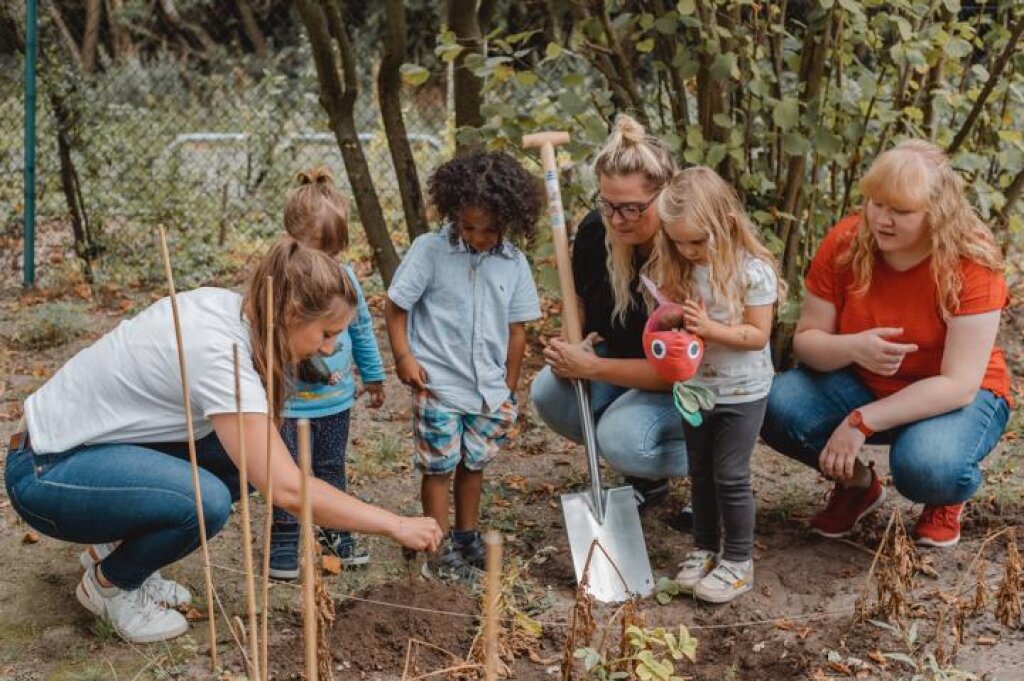 Fachkräfte und Kinder bei der Gartenarbeit in Schnelsen in der Kita Zauberburg der AWO Hamburg.